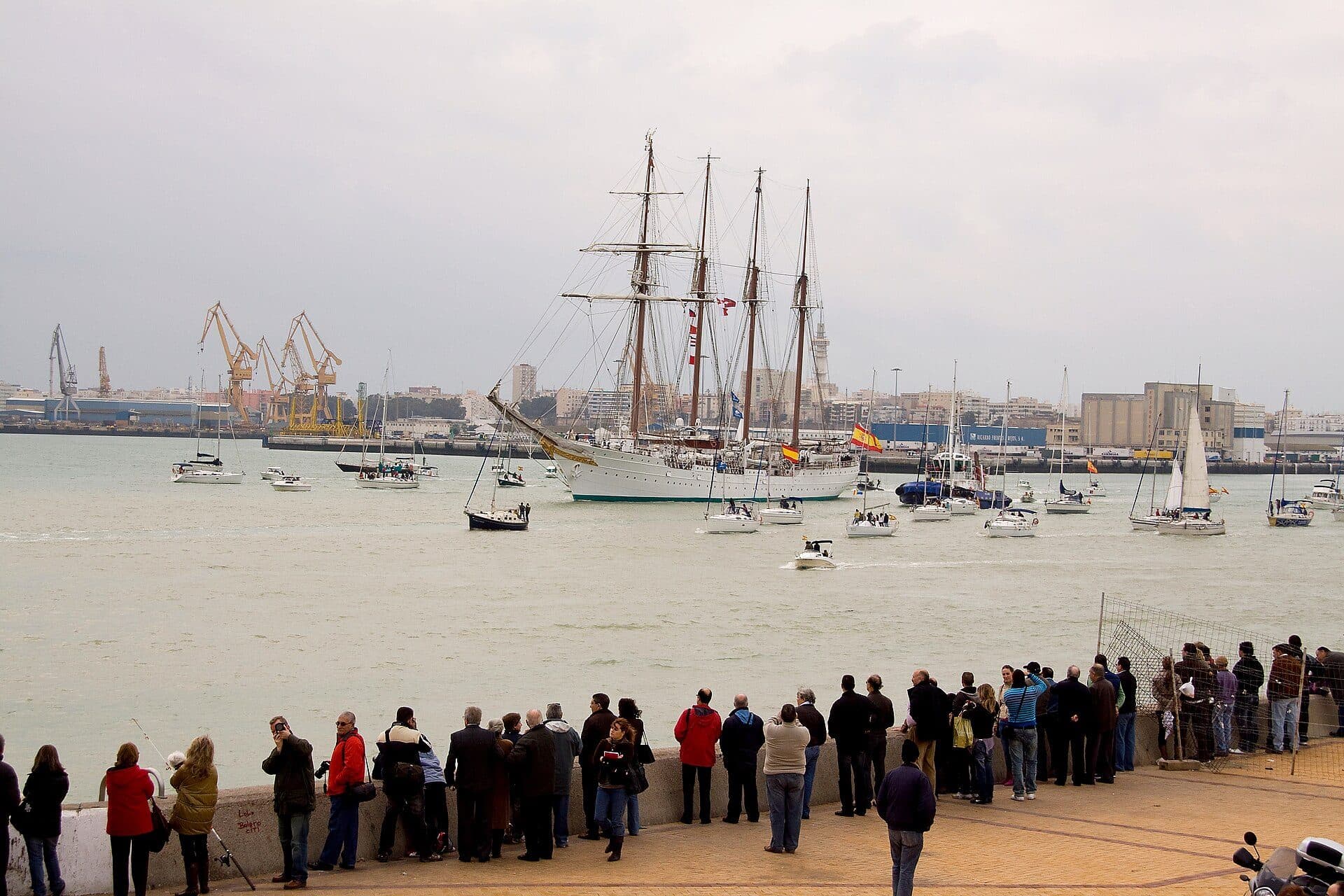 Público en el muelle despidiendo al Juan Sebastián de Elcano en la bahía de Cádiz