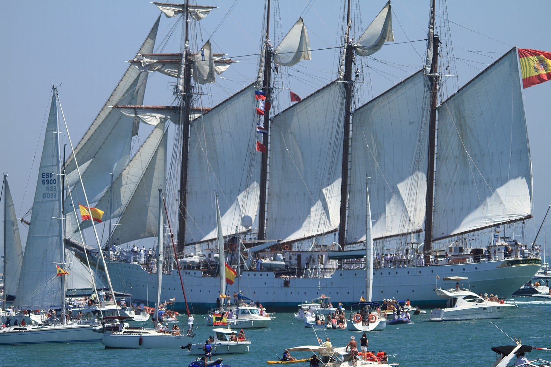 El Juan Sebastián de Elcano navegando a vela rodeado de embarcaciones